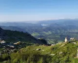 Schafe grasen auf La Rhune, mit Blick auf grüne Täler und Berge.
