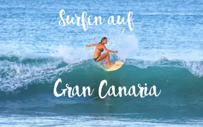 Surfen auf Gran Canaria: Eine Frau surft auf einer Welle, umgeben von Gischt.