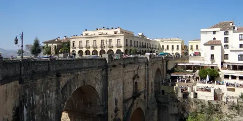 Ein perfekter tagesausflug seville: die Puente Nuevo in Ronda, mit Häusern, die sich an die Felsen klammern.