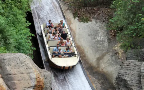 Bootsfahrt auf einer Wildwasserbahn, die durch eine üppige, grüne Landschaft führt. Die Menschen lachen und genießen die Fahrt auf der Isla Mágica.