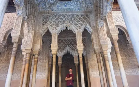Mann vor kunstvoll verzierter Säulenhalle der Alhambra. Gute alhambra tickets kaufen erfahrungen sind Gold wert!