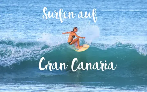 Surfen auf Gran Canaria: Eine Frau surft auf einer Welle, umgeben von Gischt.