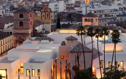 Das Picasso Museum in Spanien, Malaga, mit seinen modernen weißen Gebäuden und Palmen im Abendlicht.