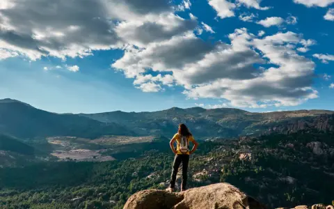Wanderin auf einem Felsvorsprung mit Blick auf die Berge, ein perfekter tagesausflug madrid.