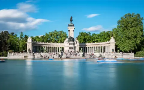 Denkmal für Alfonso XII im Retiro-Park, Spanien Madrid. Boote gleiten über den See vor der beeindruckenden Säulenhalle.