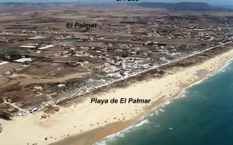 Luftaufnahme des Strandes von Vejer de la Frontera, Playa de El Palmar, mit dem Dorf El Palmar im Hintergrund.